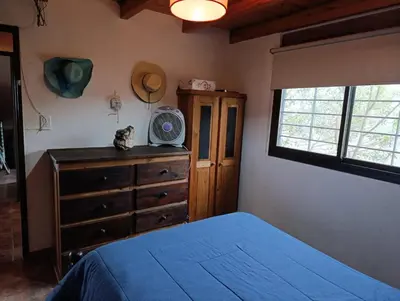 a bedroom with a bed and a dresser and a window at Flor Serrana in Cavalango