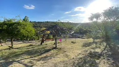 a swing set in a field with trees at Flor Serrana in Cavalango