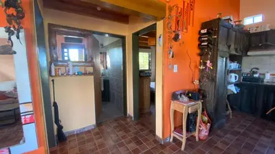 a kitchen with an orange wall and a door in a room at Flor Serrana in Cavalango