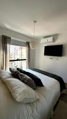 a bedroom with a bed with pillows and a window at Nva Cba, Calle Rondeau in Cordoba