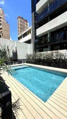 a swimming pool in front of a building at Nva Cba, Calle Rondeau in Cordoba