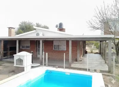 a house with a swimming pool in front of it at Sierras y sol in Villa Cura Brochero