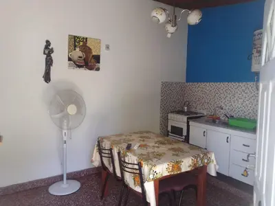a small kitchen with a table and a fan at Sierras y sol in Villa Cura Brochero