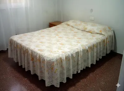 a bedroom with a bed with a white blanket on it at Sierras y sol in Villa Cura Brochero