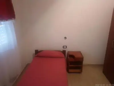 a small bedroom with two beds and a table at Sierras y sol in Villa Cura Brochero