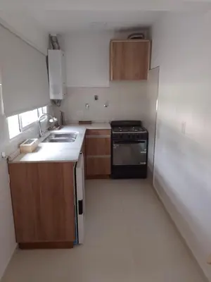 a kitchen with wooden cabinets and a refrigerator at Selene in Villa Rumipal