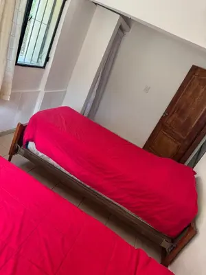 a bedroom with two beds with red sheets at Casa Villa Santa Cruz del Lago in Villa Santa Cruz del Lago