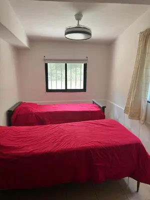 two beds in a bedroom with red sheets at Casa Villa Santa Cruz del Lago in Villa Santa Cruz del Lago