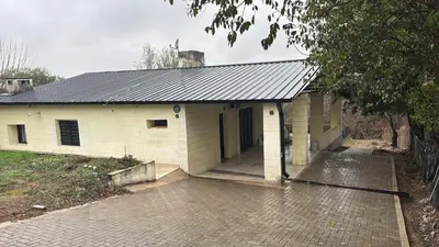 a white building with a garage with a driveway at Casa Villa Santa Cruz del Lago in Villa Santa Cruz del Lago