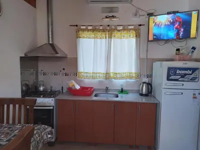a small kitchen with a sink and a refrigerator at La Nueva in Villa Ciudad Parque