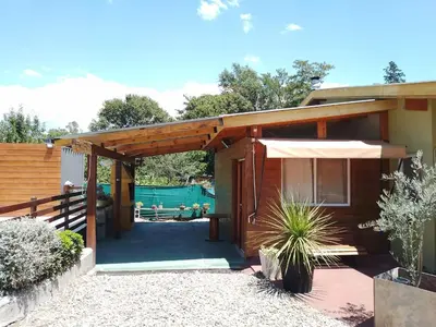 a house with a patio with a table and an umbrella at La Nueva in Villa Ciudad Parque