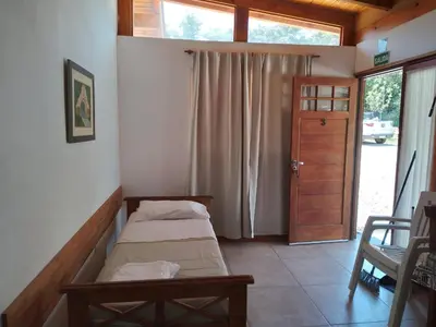 a small room with two beds and a door at La Nueva in Villa Ciudad Parque