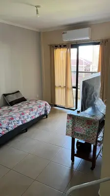 a bedroom with a bed and a chair and a window at Departamento Orlando, zona centro in Villa Carlos Paz