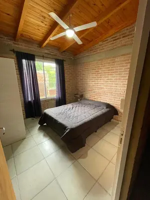 a bedroom with a bed and a ceiling fan at Cabañas Nuevos Elefantes in Villa Cura Brochero