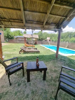 a patio with two benches and a table and a pool at Cabañas Nuevos Elefantes in Villa Cura Brochero