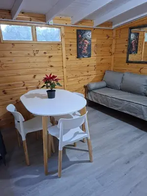 a living room with a table and chairs and a couch at Depto Cabañero Lumai in Villa Ciudad Parque