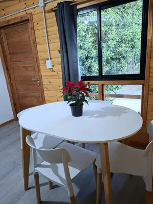 a white table and chairs in a room with a window at Depto Cabañero Lumai in Villa Ciudad Parque
