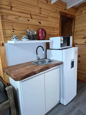 a kitchen with a sink and a refrigerator at Depto Cabañero Lumai in Villa Ciudad Parque