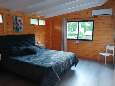 a bedroom with a bed in a wooden room at Depto Cabañero Lumai in Villa Ciudad Parque