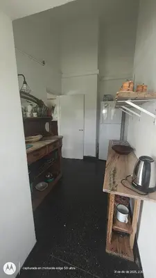 a small kitchen with a table and a refrigerator at Casa Amarilla in Santa Rosa de Calamuchita