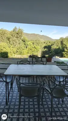 a large white table and chairs on a patio at Casa Amarilla in Santa Rosa de Calamuchita