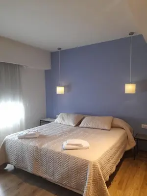 a bedroom with a large bed with two towels on it at Casa con encanto serrano in Villa General Belgrano