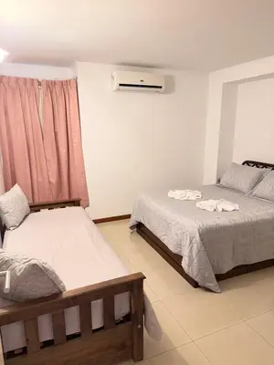 a bedroom with two beds and a couch and a window at Apartamento Carde Housing in Villa Carlos Paz