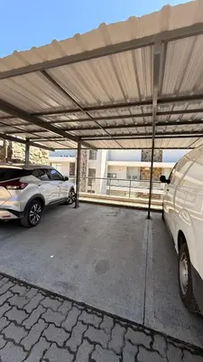 a parking lot with two cars parked in it at Apartamento Carde Housing in Villa Carlos Paz