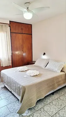 a bedroom with a large bed with two towels on it at KIN Hotel in Villa Carlos Paz