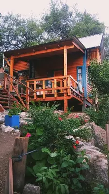 a log cabin with a porch and a deck at Cabañas Mari-Tina in Villa Serranita