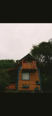 a house with a balcony on top of it at Cabañas Mari-Tina in Villa Serranita