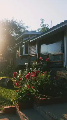 a house with flowers in the front yard at Cabañas Mari-Tina in Villa Serranita