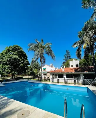 a swimming pool in front of a house with palm trees at perfecta casa en Cordoba in Cordoba