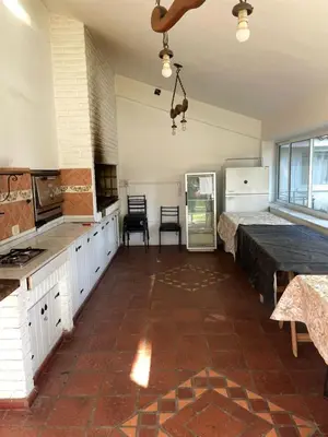 a kitchen with white cabinets and a brick floor at perfecta casa en Cordoba in Cordoba