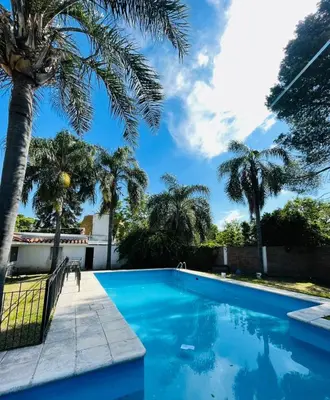 a swimming pool with palm trees in a yard at perfecta casa en Cordoba in Cordoba
