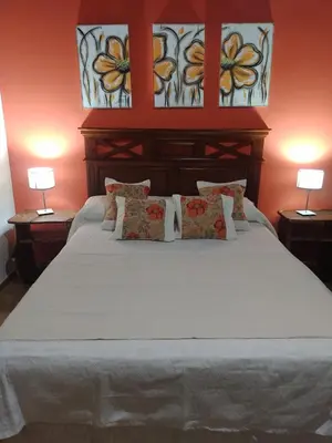a bedroom with a large white bed with stained glass windows at Cabañas Rey Garcia in Villa General Belgrano
