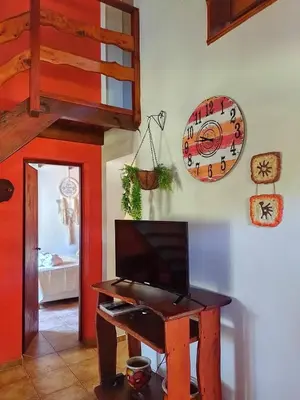 a room with a desk with a television and a clock at Cabañas Rey Garcia in Villa General Belgrano