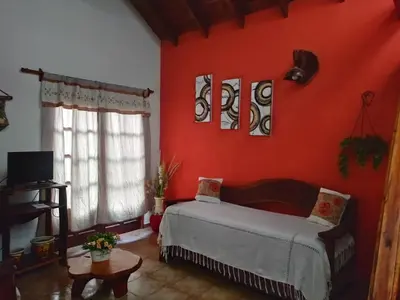 a bedroom with red walls and a bed in a room at Cabañas Rey Garcia in Villa General Belgrano