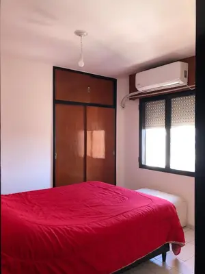 a bedroom with a red bed with a red blanket at Departamento 1 dormitorio en la mejor zona del centro de Córdoba in Cordoba