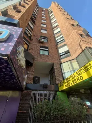 a tall brick building with a sign on it at Departamento 1 dormitorio en la mejor zona del centro de Córdoba in Cordoba