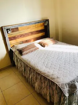 a bed with a wooden headboard in a room at Departamento Nuevo centro shopping in Cordoba