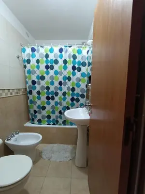 a bathroom with a sink and a toilet and a shower curtain at Departamento Nuevo centro shopping in Cordoba