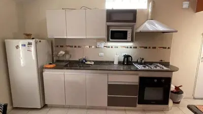 a kitchen with white cabinets and a white refrigerator at CastelAnte1 in Villa Carlos Paz
