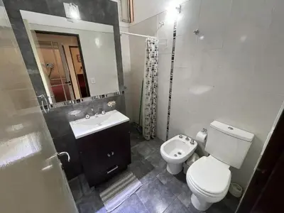a bathroom with a toilet and a sink and a mirror at CastelAnte1 in Villa Carlos Paz