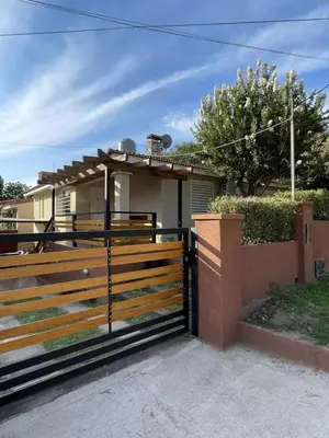a house with a wooden fence in front of it at CastelAnte1 in Villa Carlos Paz