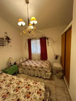 a bedroom with two beds and a chandelier at Casa Jazmín in Villa Carlos Paz