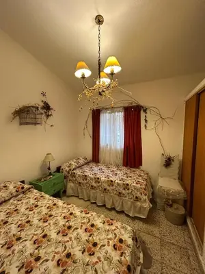 a bedroom with two beds and a chandelier at Casa Jazmín in Villa Carlos Paz