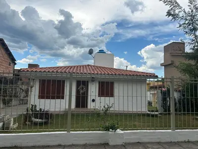 a white house with a fence in front of it at Casa Jazmín in Villa Carlos Paz