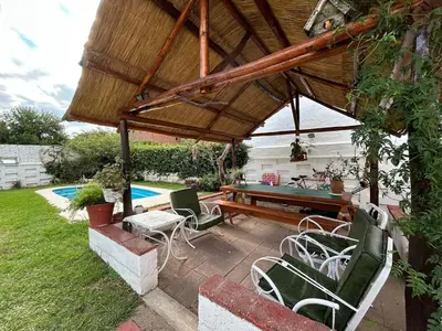 a patio with a table and chairs under a pavilion at Casa Jazmín in Villa Carlos Paz
