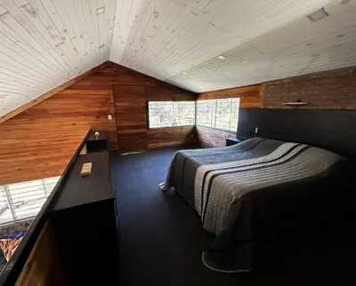 a bedroom with a bed in a room with wooden walls at Terra Nostra in Los Reartes